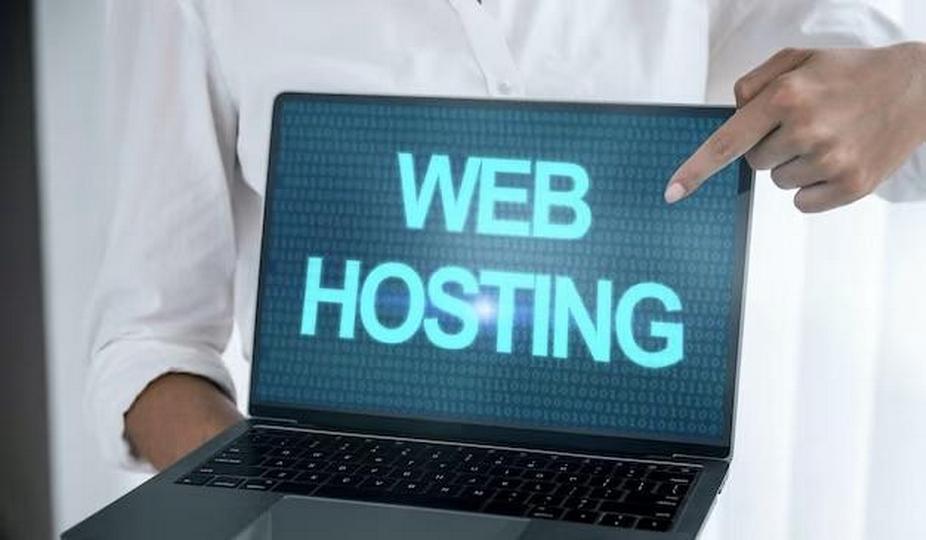 A man holds a laptop with the inscription web hosting in his hands